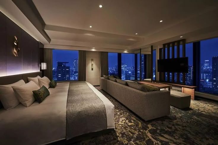Hotel suite at night overlooking a lit city skyline