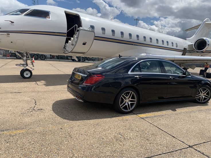 Executive saloon car waiting beside a private jet on the tarmac